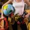 a woman wearing a tool belt and holding an inflatable globe under her arm