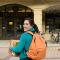 Student and mother walking with boxes toward campus building