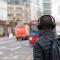 Closeup of young man wearing headphones standing on city street corner