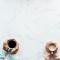 Closeup of two sets of hands holding coffee mugs