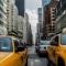 Yellow taxis on a crowded city street surrounded by skyscrapers