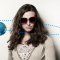 a woman with sunglasses and a small picture of Earth revolving around her head