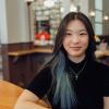 woman sitting at coffee shop and smiling at camera