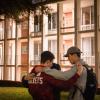 three male students praying for each other on campus 