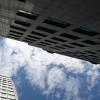 a blue sky with white clouds above two skyscrapers