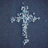 A white and gray cross formed out of small pebbles