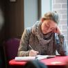 a woman seated at a round table and journaling