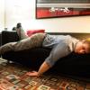 Young man in office clothes sprawled across couch