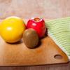 a wooden table with fruits, vegetables, and knife