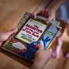 The hands of two children fighting over picture book