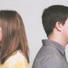Man and woman facing opposite ways, standing back to back
