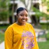 a female student on campus wearing a long-sleeved yellow shirt