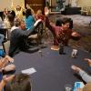 Group of students playing game at tables, cheering and smiling