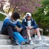 Two students praying for each other outside on stone steps