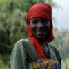 Young African woman smiling wearing red headwrap and green dress