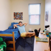 Student sitting with legs propped up on desk in freshmen dorm room