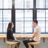 Young man and woman talking, seated in coffee shop