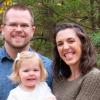 Photo of Ryan with wife and infant daughter standing in forest