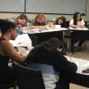 Group of students seated at tables writing letters to incoming freshmen