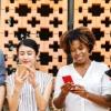 Group of people all staring at smartphones standing side by side