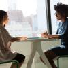 Two young women sitting at table in coffee shop