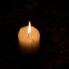 a small candle burning in darkness