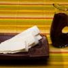 Communion elements on table: strips of flatbread on a wooden plate, a pitcher of juice, and a plain ceramic cup
