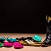 Pile of multicolored flip-flops and set of black cowboy boots