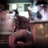 a glass cup half-full with beer and a half-empty beer pitcher on a bar