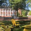 three yellow chairs on a campus quad with an academic building in the background