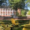 three yellow chairs on a campus quad with an academic building in the background