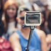 a person holding a selfie stick in front of their friends