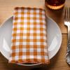 table place setting on wood table with brown and white napkin