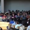 a large group of students listening to a man speak 