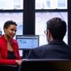 Woman and man wearing business casual clothes talking in office 