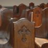 wooden pews with a cross engraved on their side.