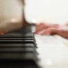 Closeup of person's hands on piano keys