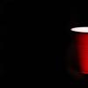 a red plastic up against a black background.