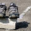 Pair of running shoes sitting on top of rock on the pavement