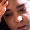 Woman pressing hand to forehead looking discouraged