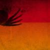 Dark silhouette of heart with wings against orange yellow background