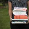 Person holding massive stack of textbooks