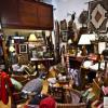 Woman shopping at antique store full of furniture and random knickknacks
