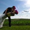 Bride and groom kissing in front of cornfield